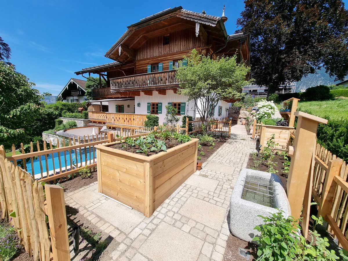 Bauerngarten mit Bauernhaus im Hintergrund